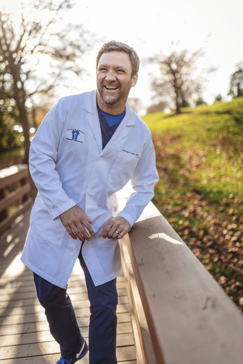 A dentist with a mask on and holding a dental tool