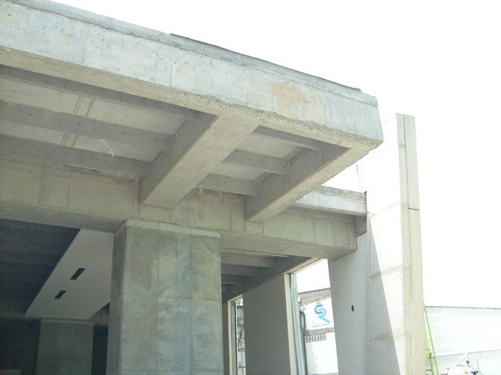 Edificio de hormigón en construcción con vigas, columnas y losas expuestas.
