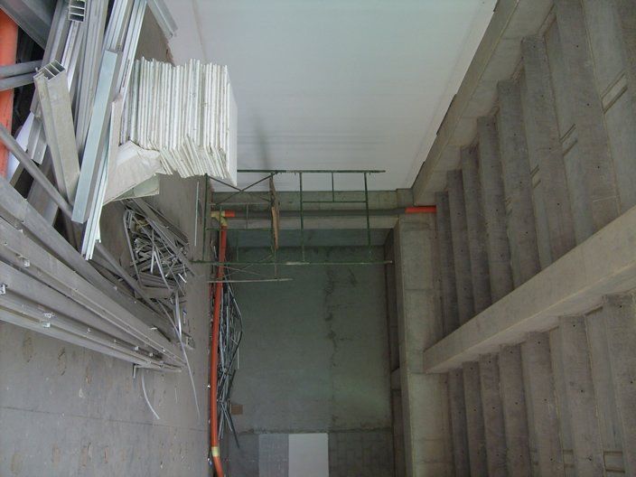 Sitio de construcción: paneles de yeso, estructuras metálicas, conductos eléctricos y paredes y escaleras de hormigón.