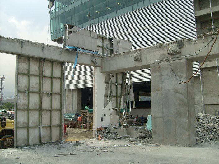 Demolición de edificio de hormigón. Paredes y pilares de hormigón gris dañados, escombros esparcidos.