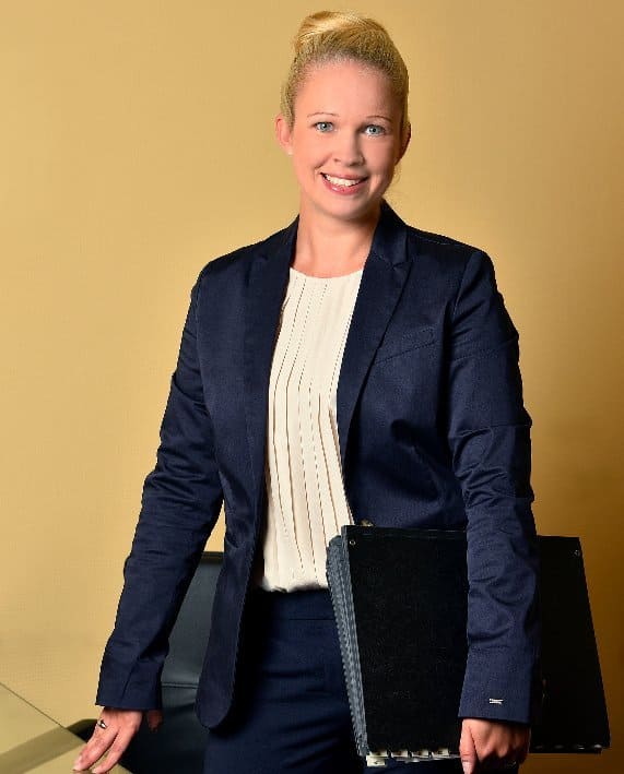 Eine Frau im Anzug hält einen schwarzen Ordner