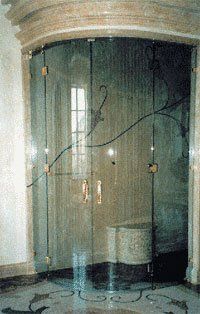 Corner shower with decorative tile and rounded glass door