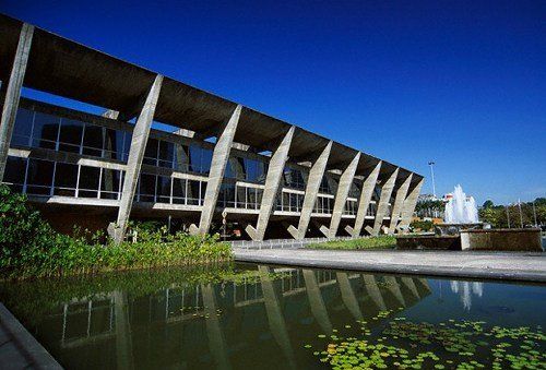 Um grande edifício com um lago na frente