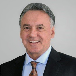 A man in a suit and tie is smiling for the camera.