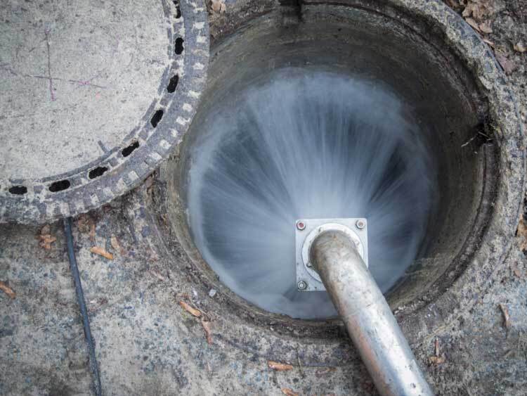 Open-sewage-channel-access-with-escaping-water-jet-on-the-mounted-high-pressure-water-pipe