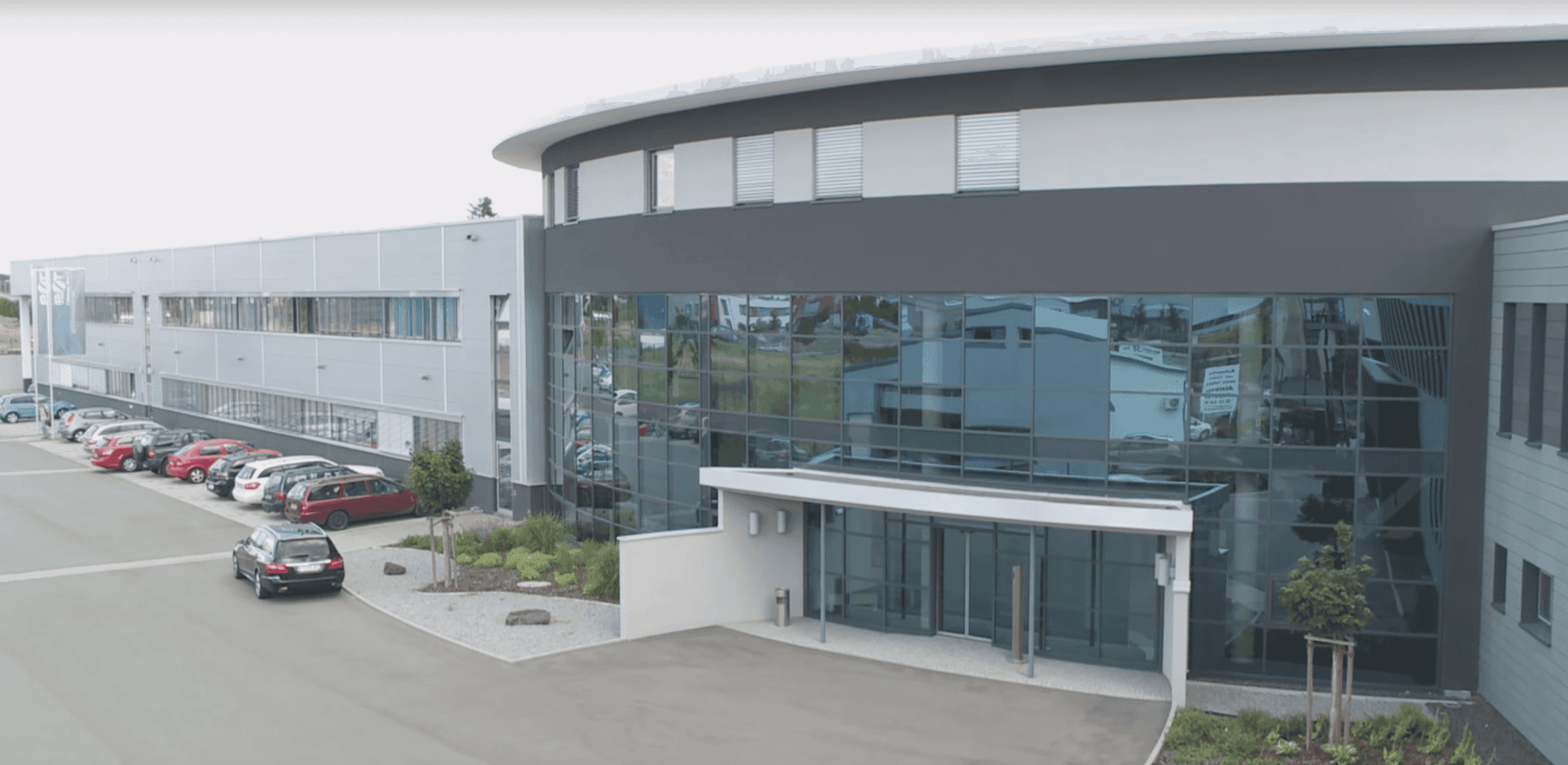 A large building with a lot of cars parked in front of it.