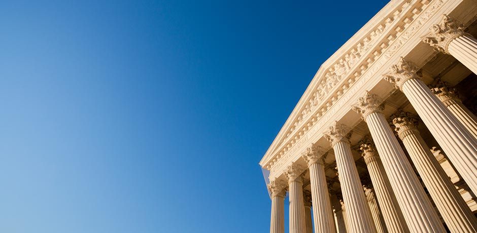 A large building with columns and a blue sky in the background.