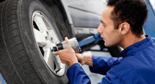 A mechanic at work on a car wheel