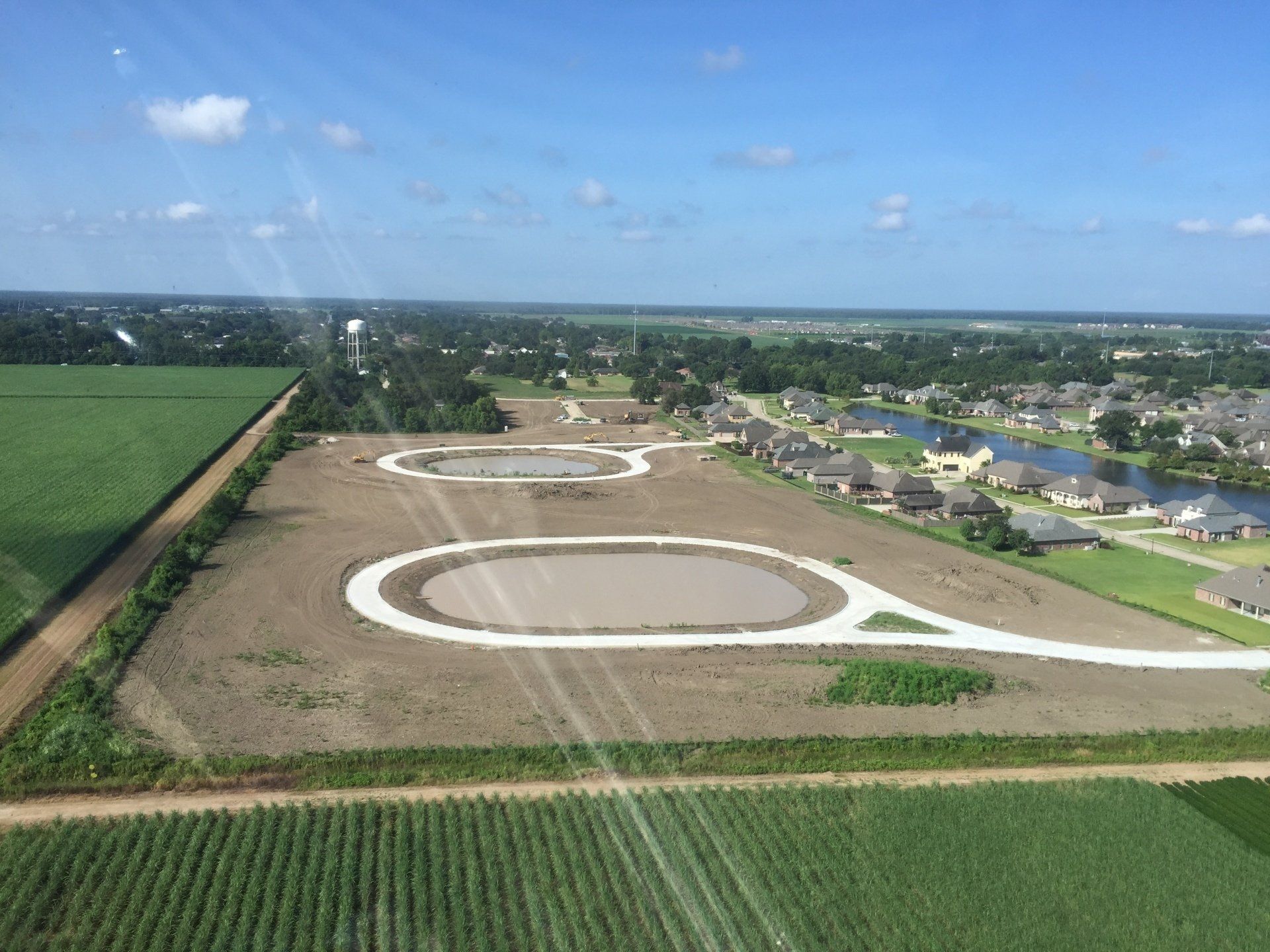 An aerial view of a residential area surrounded by fields and houses.