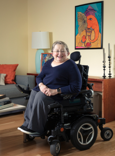 A woman in a wheelchair is smiling in a living room