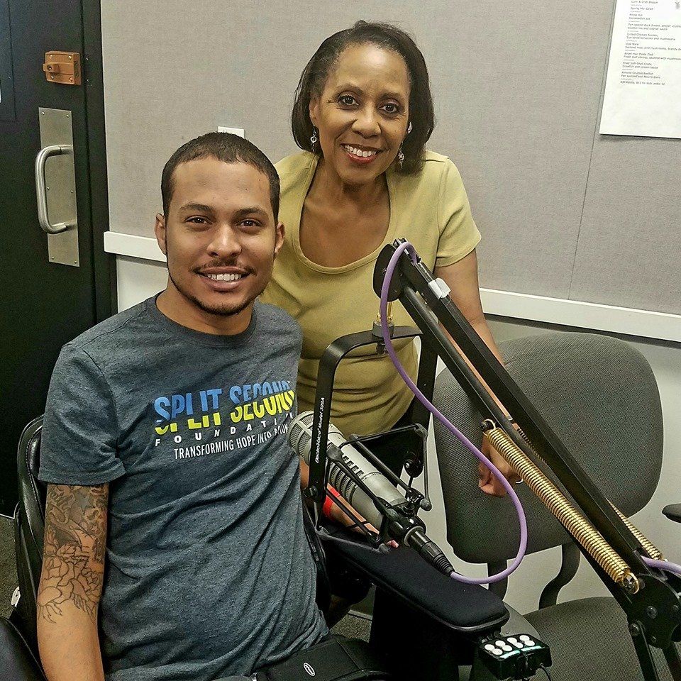 A man wearing a split screen shirt sits next to a woman