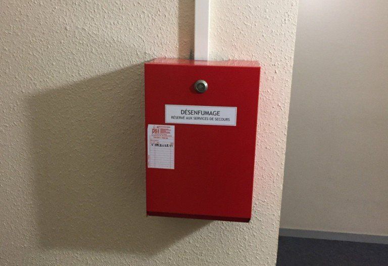 Une boîte rouge avec un autocollant dessus qui dit « défibrillateur »