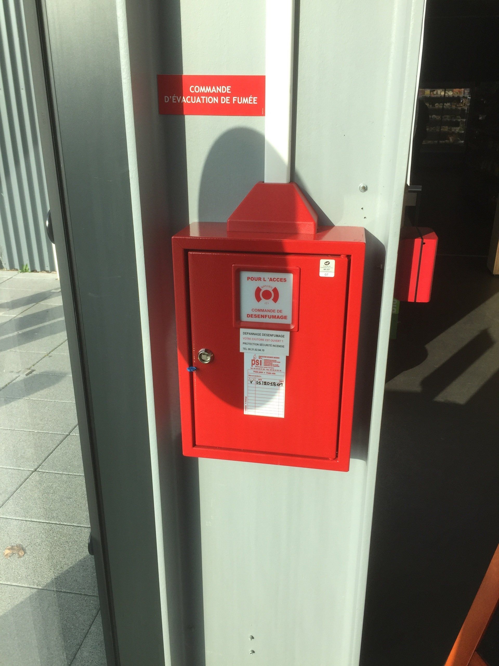 Une boîte rouge sur un mur avec écrit « urgence » dessus