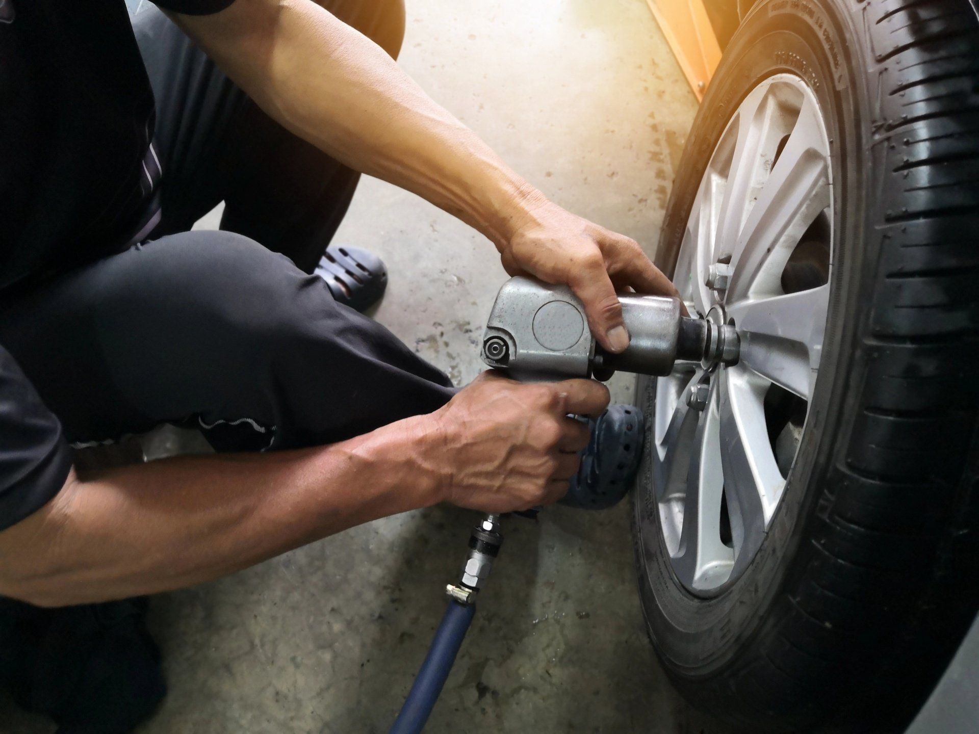 Automechaniker führt einen Reifenwechsel durch.