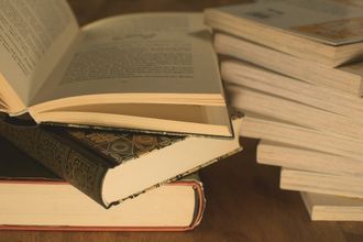 A stack of books sitting on top of each other on a wooden table.