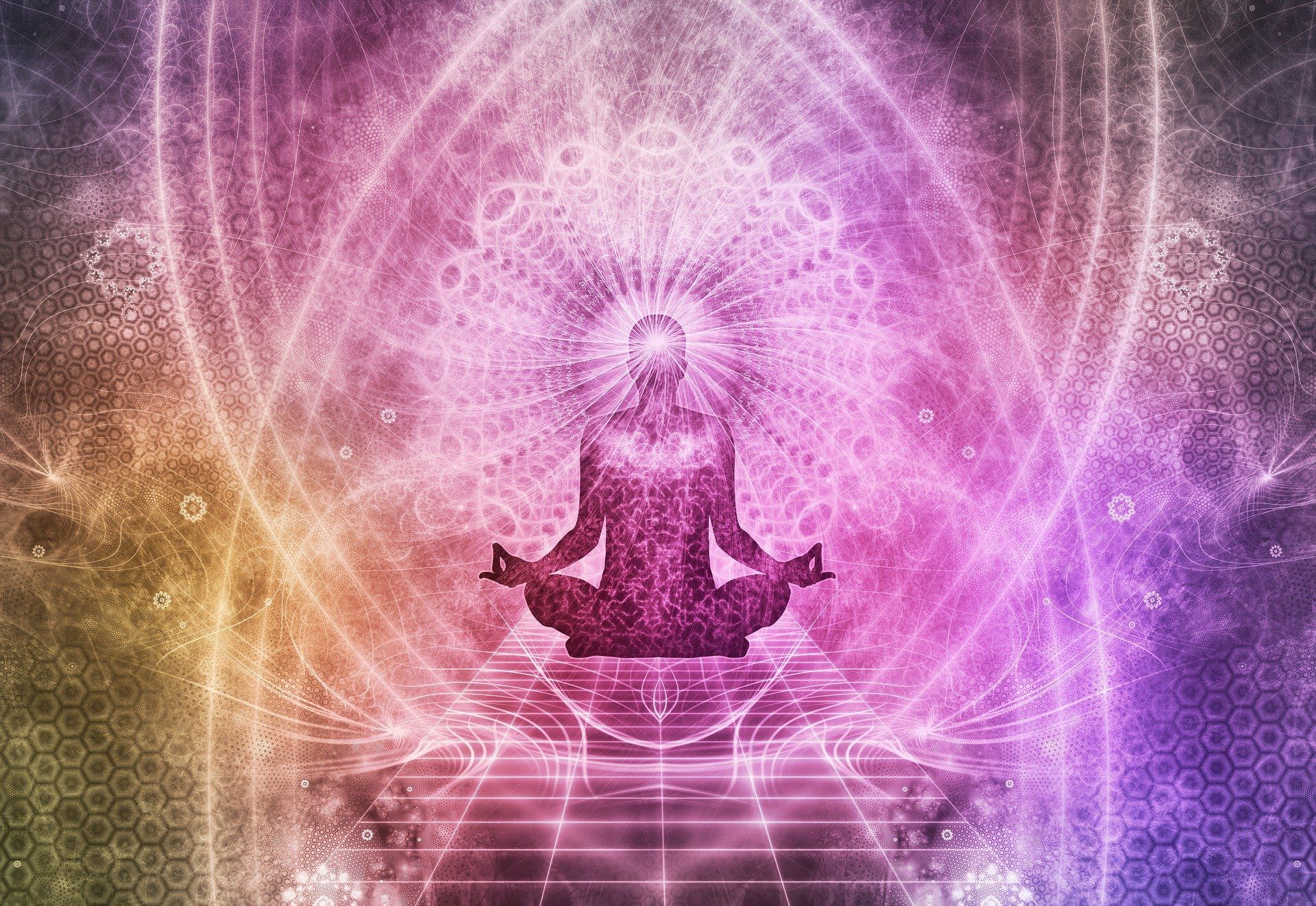 A person is sitting in a lotus position in front of a colorful background.