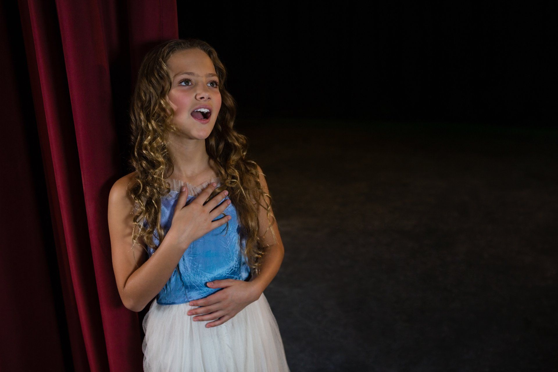 Young girl singing on stage