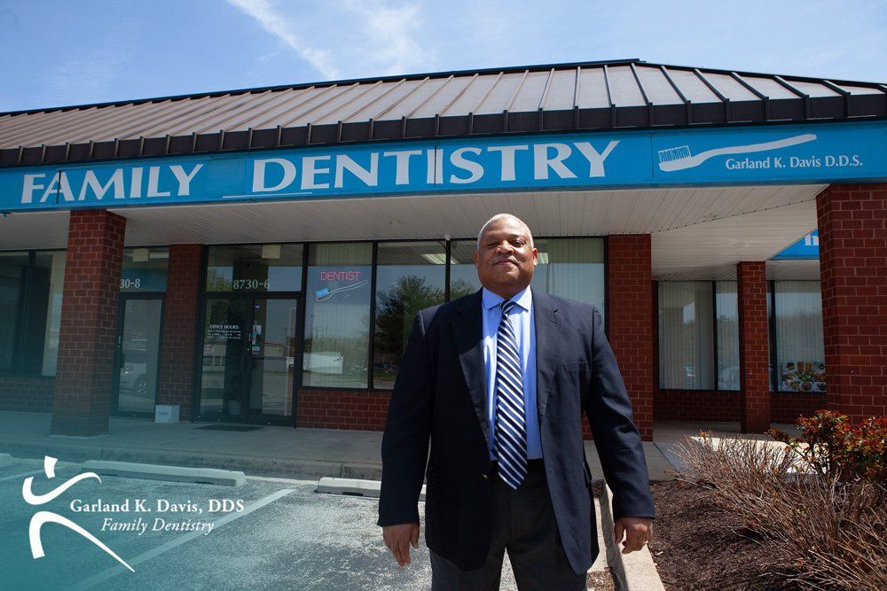 Dr. Davis in a suit and tie stands in front of a family dentistry