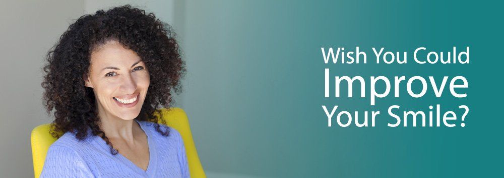 woman smiling on a yellow chair - image header - Garland K. Davis, DDS Family Dentistry