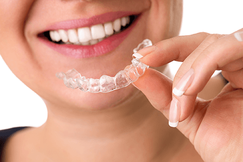 Woman holding Invisalign tray