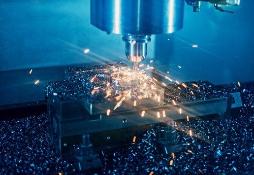 Macchina CNC che taglia il metallo, scintille volanti, ambiente dai toni blu.