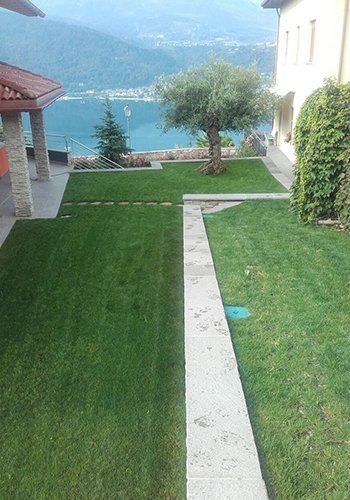 un prato accanto a una villa e vista di un lago