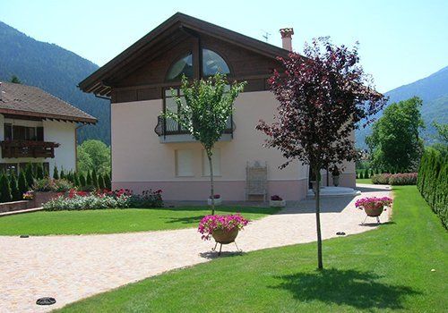 una villetta con vista delle montagne, del prato e vasi di fiori
