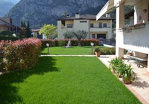 una villa accanto a un prato verde e due lampioni
