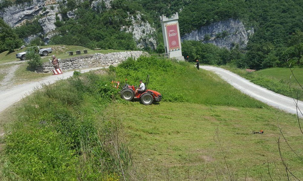 Un uomo su un tagliaerba in un prato di una zona di montagna