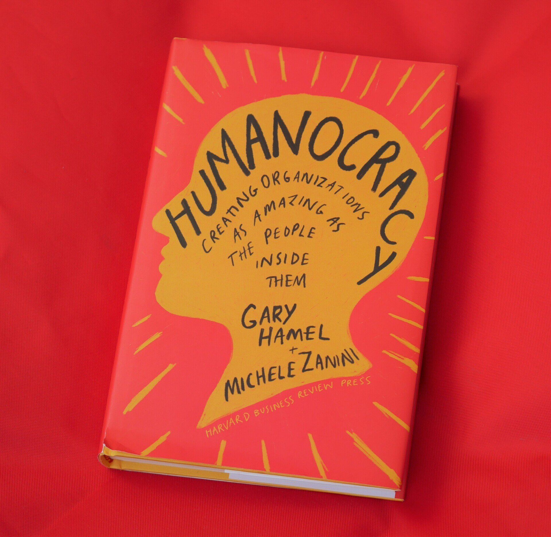A red book with a gold silhouette face on it