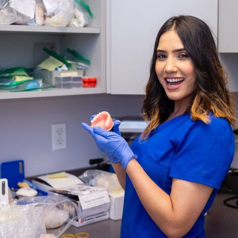 Wisdom Teeth Extractions — Dentist Holding Denture in Liberty Township, OH
