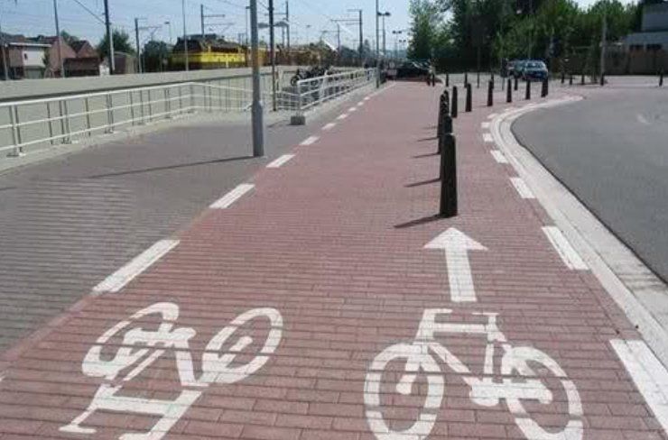 A bike lane on a brick road with arrows pointing to the right