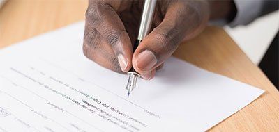 person signing a contract - digital marketing agencies often lock you into long-term contracts