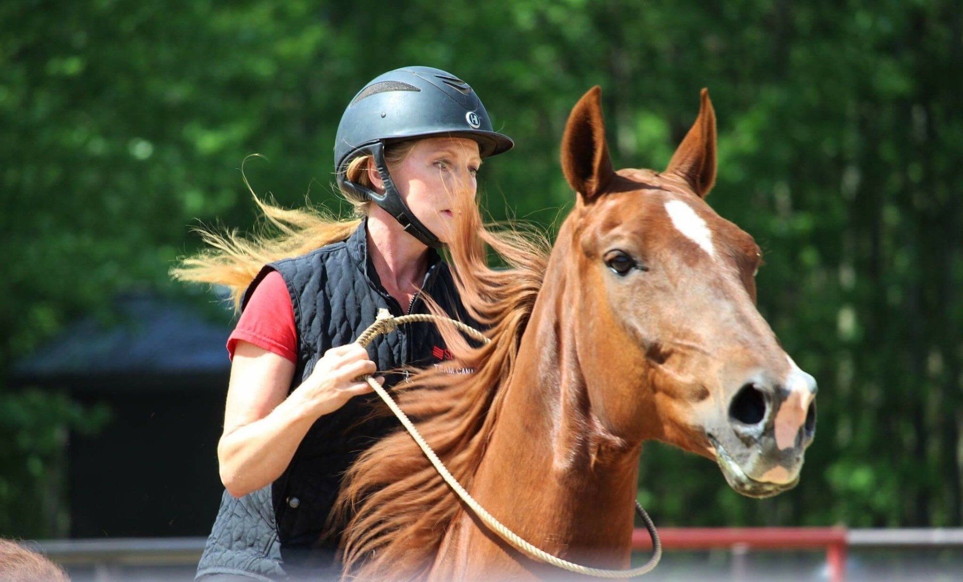 Woman in black helmet riding a horse