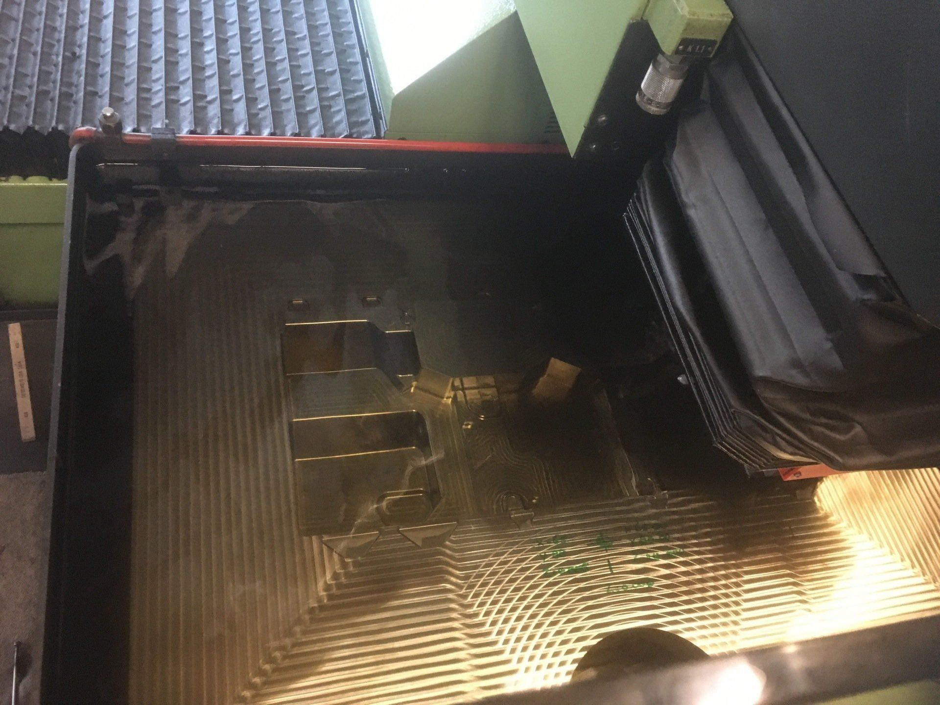 A machine is cutting a piece of metal on a table.