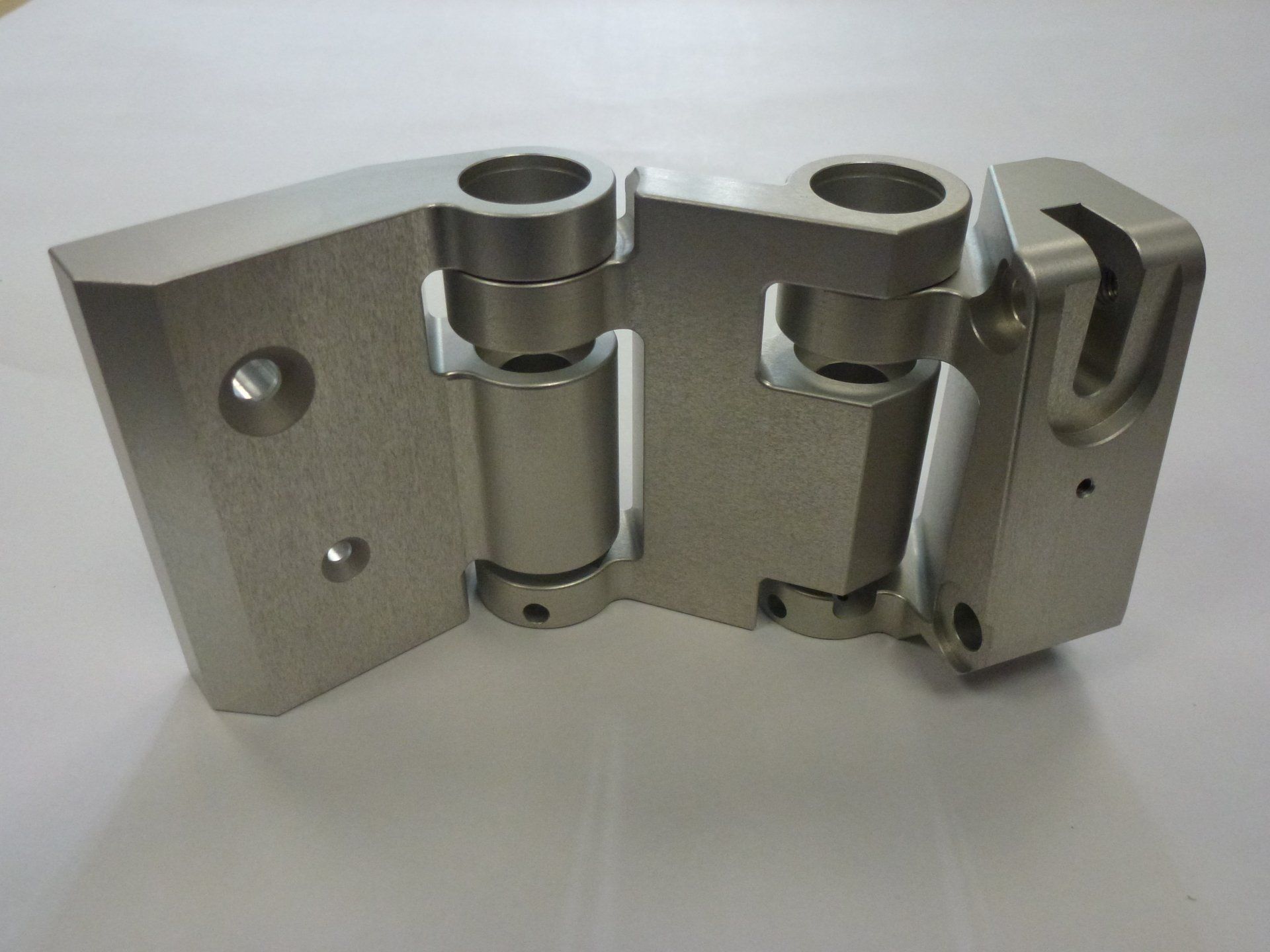 A close up of a metal piece on a white surface