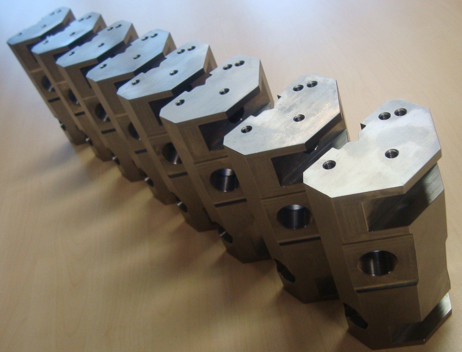 A row of metal pieces are lined up on a table