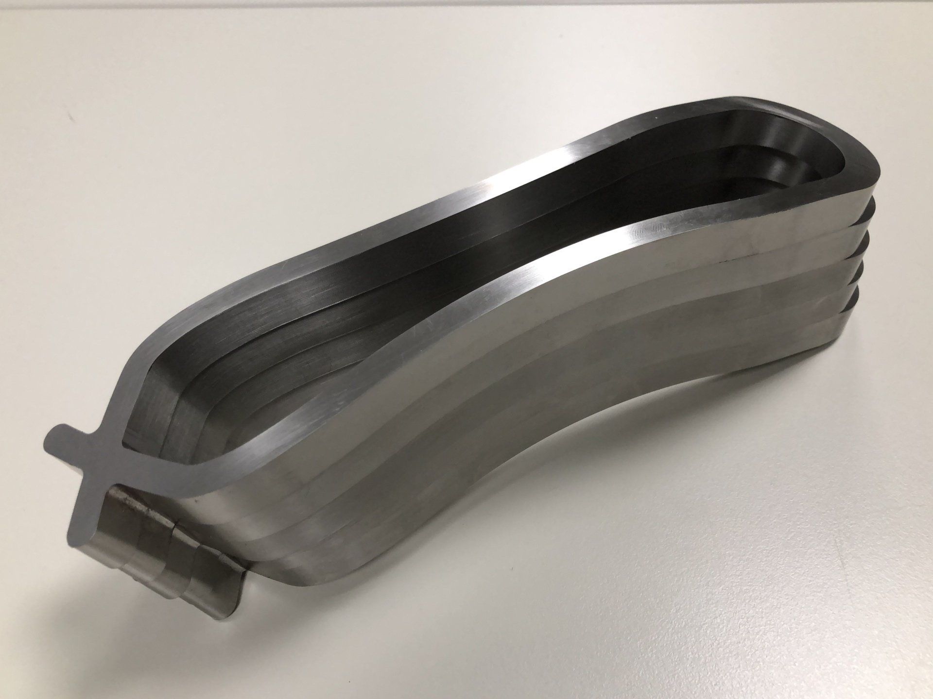 A metal object is sitting on a white surface.
