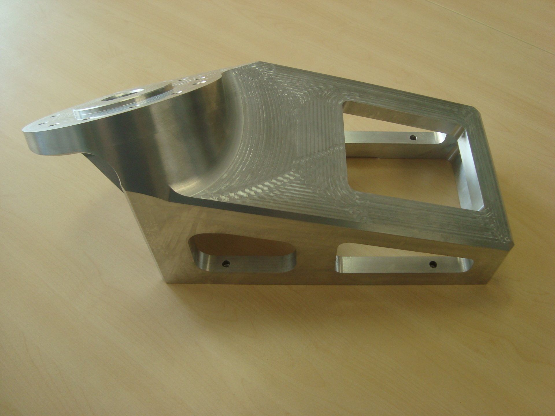 A piece of metal is sitting on a wooden table.