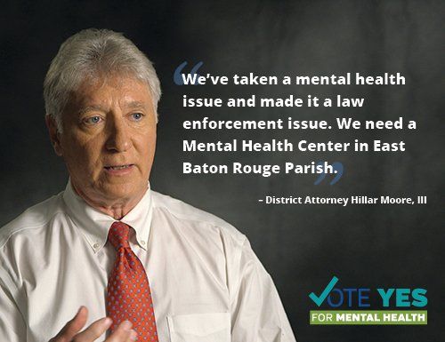 District Attorney Moore advocates for a mental health center. He’s wearing a white shirt and red tie, with text on a dark background.