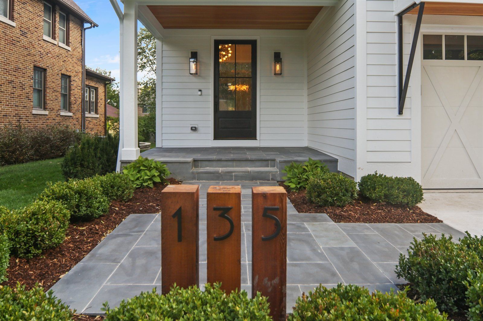 The front of a house with the number 135 on the sidewalk