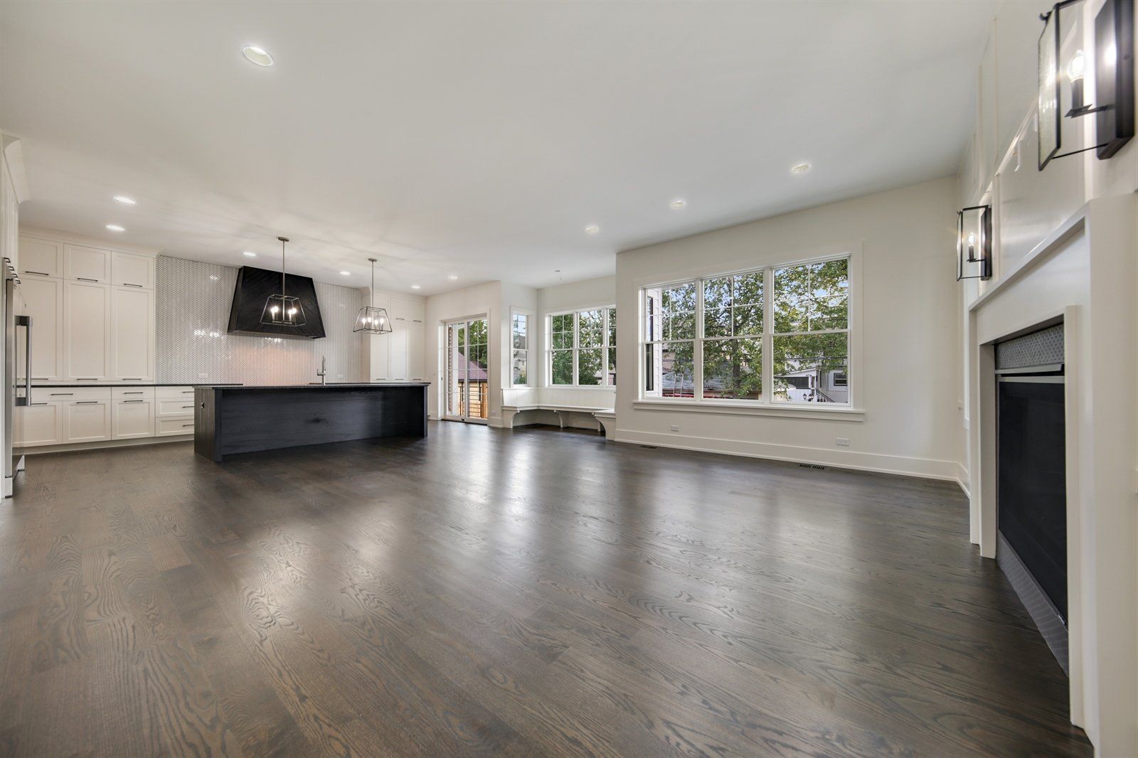 A large empty living room with hardwood floors and a fireplace.