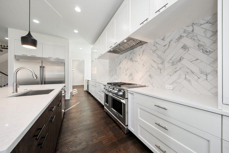 A kitchen with white cabinets and stainless steel appliances.