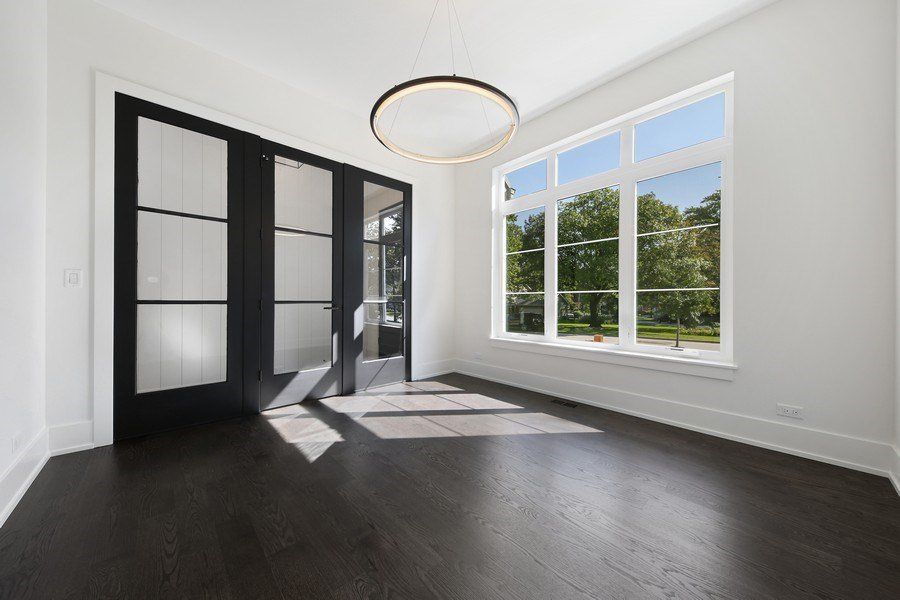 An empty room with a lot of windows and hardwood floors.