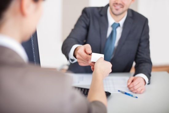 offering his business card to the expert