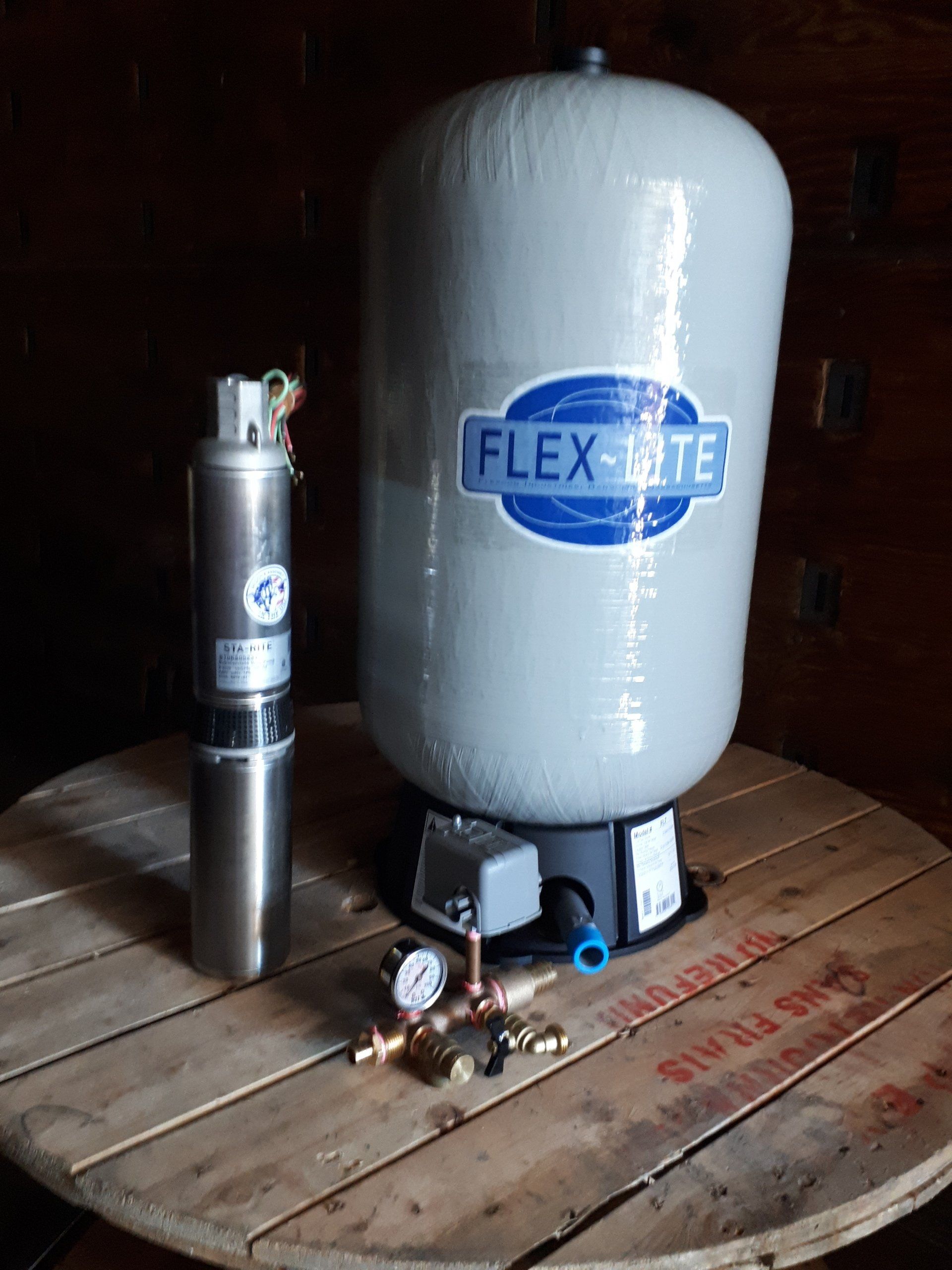 Flex-Lite air tank and compressor unit on a wooden floor, with gauges and valves attached.