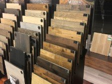Display of various wood flooring samples in a showroom, showcasing different colors and textures.