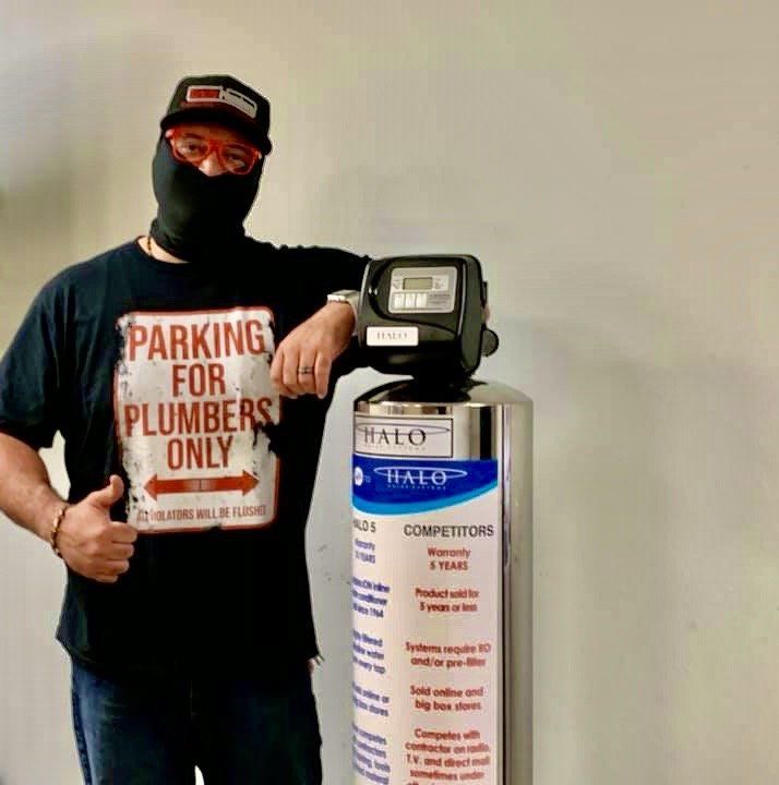 A man wearing a mask and a shirt that says parking for plumbers only