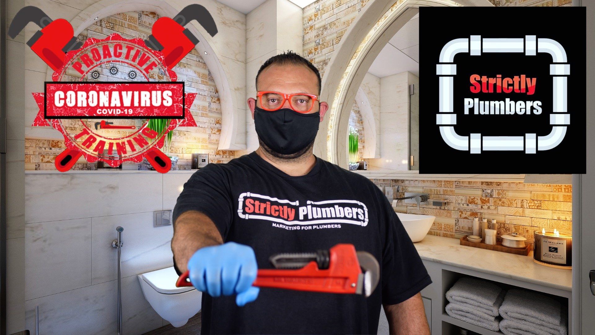 A man wearing a mask and gloves is holding a wrench in a bathroom.