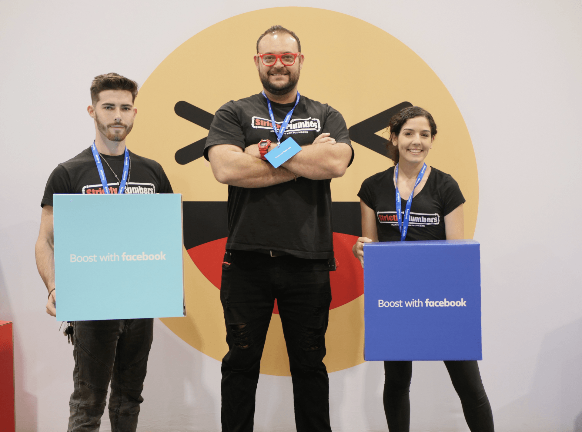 A man and two women are holding signs that say boost with facebook